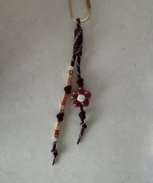 Burgundy cord keychain with small letter beads, hearts and a flower on a brass ring