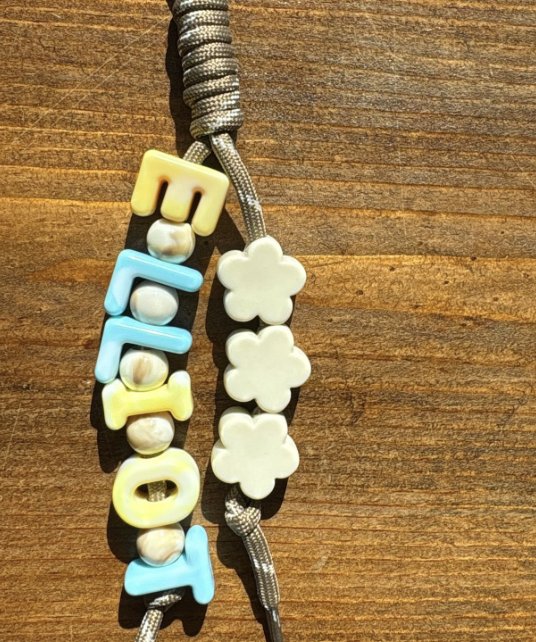 Keychain spelling Elliot in pastel letters with cream flower beads