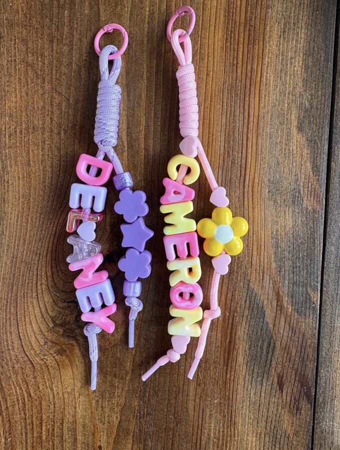 Two keychains spelling Delaney and Cameron in pastel letter beads with flower, star and heart beads